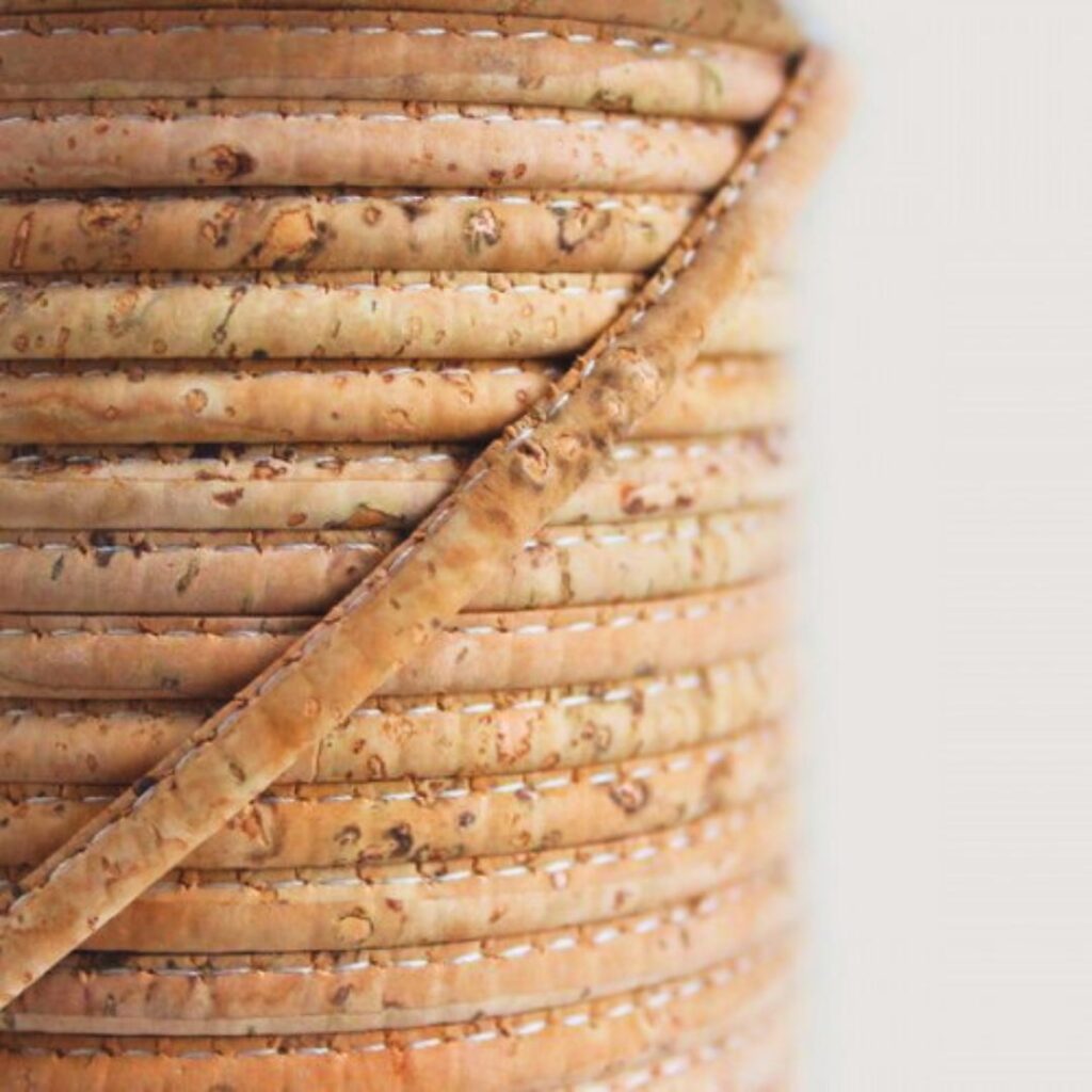 Fios de cortiça portuguesa premium em detalhe, mostrando a textura macia e a coloração natural da matéria-prima utilizada na Linha Vahani.