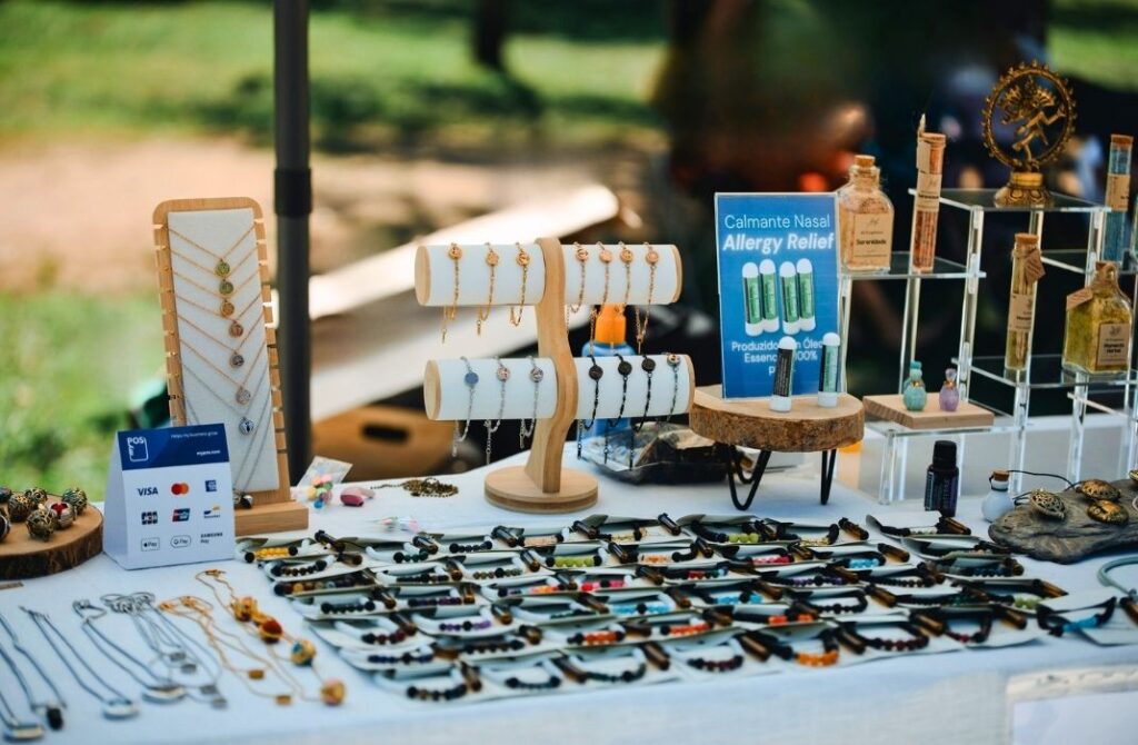 Exposição detalhada dos produtos Swaminah em uma mesa organizada, apresentando óleos essenciais, miniaturas terapêuticas e pulseiras de ancoragem sensorial.
