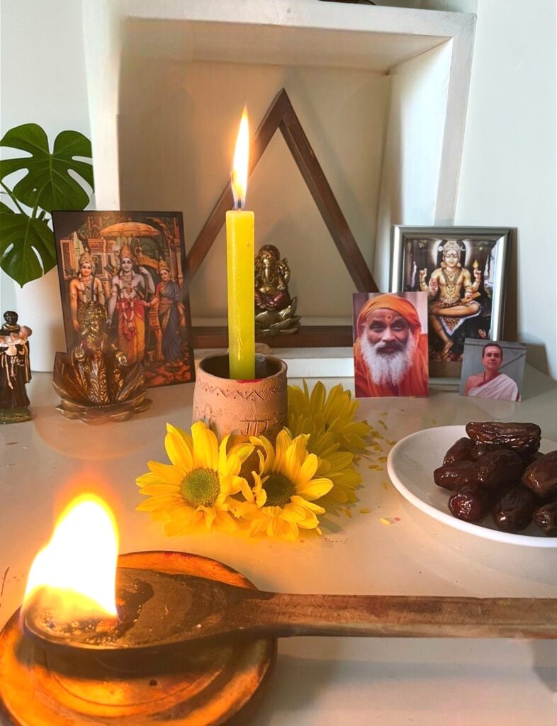 Altar tradicional de Vedanta com a imagem de Swami Dayananda Sarasvati, flores e chamas de velas, representando a linhagem e o estudo da fundadora da Swaminah.